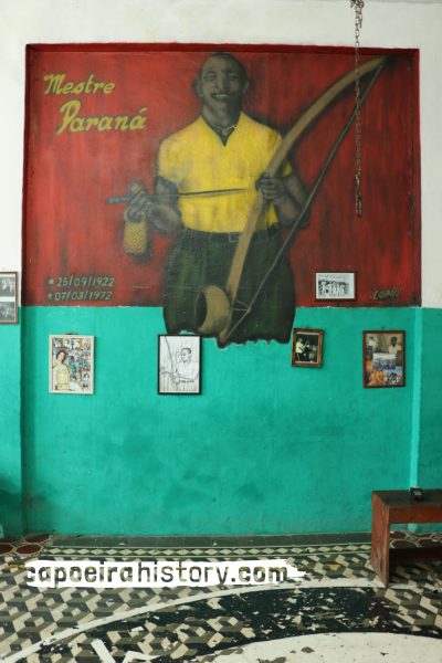 Parede da academia de Mintirinha com quadros e painel em homenagem a Paraná.